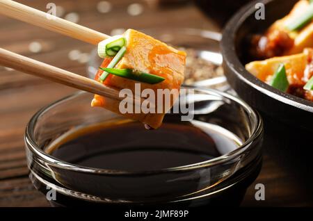 Plat de tofu Mapo de caillé de soja maintenu dans des baguettes Banque D'Images