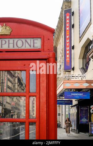 LONDRES - 18 mai 2022 : entrée du théâtre Adelphi avec téléphone britannique rouge traditionnel en premier plan Banque D'Images