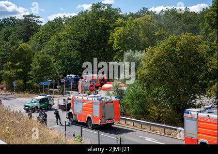 Berlin, Allemagne. 06th août 2022. Les moteurs d'incendie et les véhicules de police se trouvent près de la scène de l'incendie. Jeudi, un incendie a éclaté à Grunewald sur le site de dynamitage de la police de Berlin. Le site de dynamitage stocke les munitions que les experts en la matière rendent normalement inoffensives. Credit: Christophe bateau/dpa/Alay Live News Banque D'Images