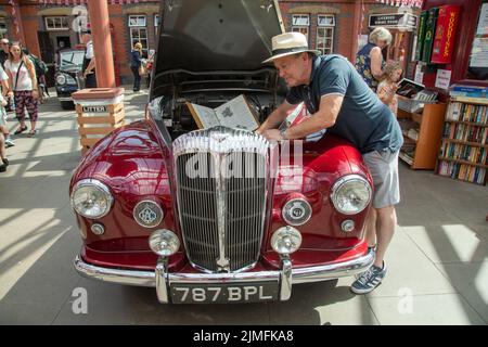 Kidderminster, Worcs, Royaume-Uni. 6th août 2022. Robert Back se réfère à son manuel de voiture original alors qu'il prépare son Daimler Conquest 1956, un projet de fierté et de joie qui a pris 10 ans de travaux de restauration, à l'Extravaganza de transport Vintage à Kidderminster, Worcestershire. L'événement annuel comprend des moteurs à vapeur ainsi que des véhicules automobiles d'époque. Crédit : Peter Lophan/Alay Live News Banque D'Images