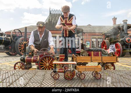 Kidderminster, Worcs, Royaume-Uni. 6th août 2022. Michael Pryce, passionné de vapeur, montre sa fierté et sa joie grâce à son moteur de traction à vapeur miniature à l'échelle 1:3, « Mokey Joe », en compagnie de Jim Parker, à l'occasion de l'Extravaganza de transport d'époque du Severn Valley Railway, à Kidderminster, dans le Worcestershire. L'événement annuel comprend des véhicules automobiles d'époque ainsi que des moteurs à vapeur. Crédit : Peter Lophan/Alay Live News Banque D'Images