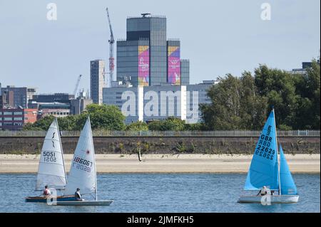 Réservoir Edgbaston, Birmingham, Angleterre, 6 août 2022. - Les marins de loisirs ont pris dans les eaux basses du réservoir Edgbaston au soleil torant samedi après-midi. Les bateaux ont passé la toile de fond du centre-ville avec la Tour BT et 103 Colmore Row avec la signalisation des Jeux du Commonwealth. Le niveau d'eau est très bas en raison de plusieurs semaines de temps sec. Photo par crédit : Michael Scott/Alay Live News Banque D'Images