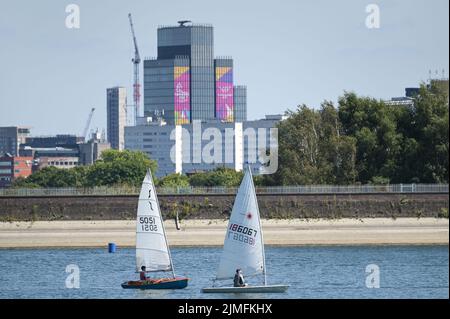 Réservoir Edgbaston, Birmingham, Angleterre, 6 août 2022. - Les marins de loisirs ont pris dans les eaux basses du réservoir Edgbaston au soleil torant samedi après-midi. Les bateaux ont passé la toile de fond du centre-ville avec la Tour BT et 103 Colmore Row avec la signalisation des Jeux du Commonwealth. Le niveau d'eau est très bas en raison de plusieurs semaines de temps sec. Photo par crédit : Michael Scott/Alay Live News Banque D'Images