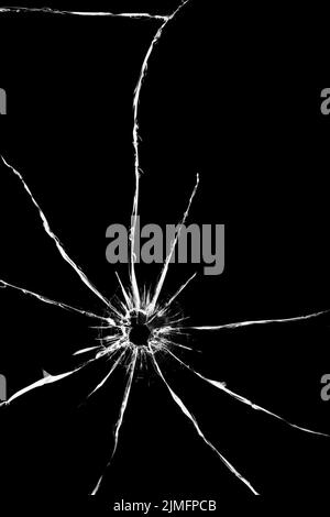 Trou d'un tir avec une arme dans le verre. Fissures à l'arrière de la voiture. Texture sur fond noir, l'effet de cassé Banque D'Images