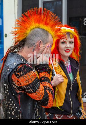 Un couple avec des coiffures de Punk Orange à Blackpool, Lancashire, Royaume-Uni. 6th août 2022. La sous-culture, les idéologies et la mode punk, avec Mohican, coiffures teints et coloriage au festival Punk Rebellion aux jardins d'hiver. Une protestation contre les attitudes et les comportements conventionnels, un choc des cultures anti-establishment, des mohawks, des épingles de sécurité et une charge d'attitude à la ville de bord de mer tandis que les punks participant au festival annuel de musique rock Rebellion aux jardins d'hiver se côtoient avec les vacanciers traditionnels. Crédit; MediaWorldImages/AlamyLiveNews Banque D'Images