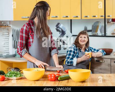 fille mère cuisson salade thé temps ensemble Banque D'Images
