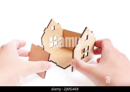 Mains d'assemblage d'un kit de maison de jouet en bois, vue de la première personne. Banque D'Images