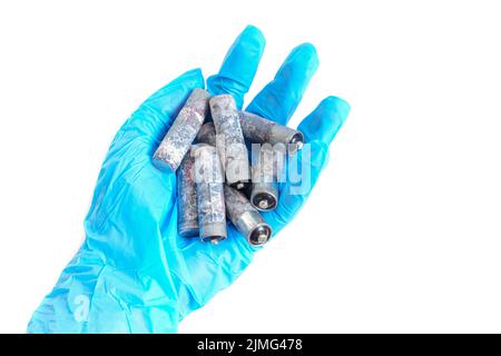 Lot de piles AA fortement corrodées isolées à la main sur fond blanc. Risques toxiques liés à la mise au rebut de la batterie. Banque D'Images