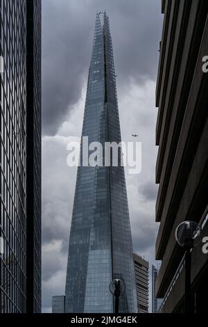 Londres, Royaume-Uni - Jun 09 2022: Vue du Shard entre les maisons avec un avion au loin, les plus belles rues de Londres papier peint Banque D'Images