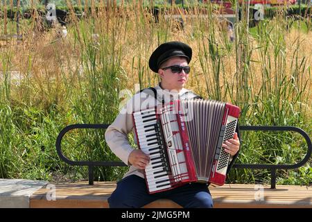 Nijni Novgorod, Russie, St. Sovnarkomovskaya 13, 07.30.2022. Le musicien joue l'accordéon dans la rue en été. Banque D'Images