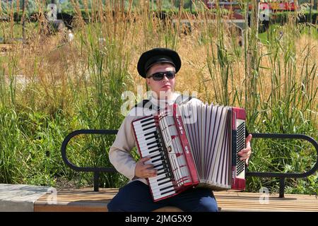 Nijni Novgorod, Russie, St. Sovnarkomovskaya 13, 07.30.2022. Le musicien joue l'accordéon dans la rue en été. Banque D'Images