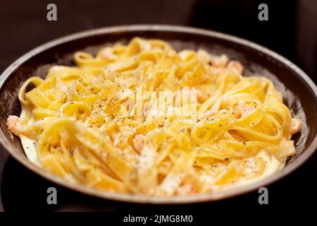 Pâtes tagliatelles aux crevettes dans une poêle à frire Banque D'Images