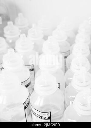 Beaucoup de bouteilles de médecine en plastique blanc identiques, avec l'accent sur l'un d'entre eux. Banque D'Images