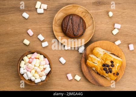 Vue de dessus du gâteau au chocolat cacao Marshmallow dans un plat en bois. Banque D'Images