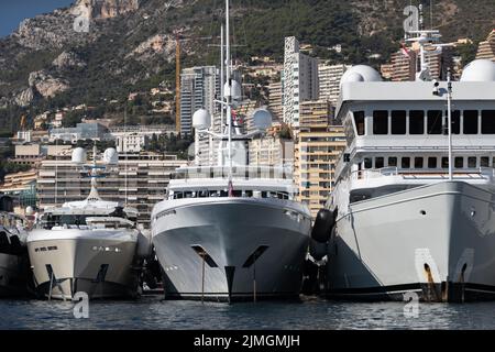 Beaucoup de yachts énormes sont dans le port de Monaco à la journée ensoleillée, Monte Carlo, la montagne est sur fond, panneau brillant du bateau à moteur, Banque D'Images