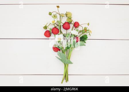 Bouquet de fraises avec fleurs, bouquet de fraises sur fond blanc en bois Banque D'Images