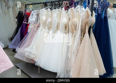 Beaucoup de robes de soirée et robes de mariée différentes sur un cintre dans le magasin Banque D'Images