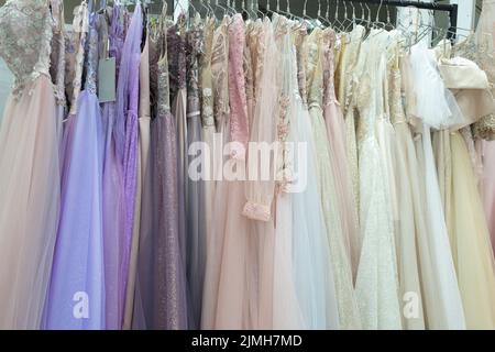 Beaucoup de robes de soirée et de mariée différentes gros plan sur un cintre dans un magasin Banque D'Images