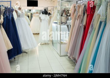 Beaucoup de robes de soirée et de mariée différentes sur un cintre dans un magasin général Banque D'Images