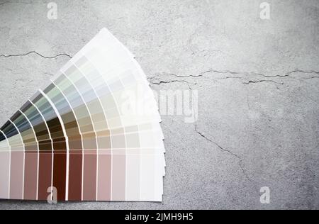 Échantillons de peinture nuance de couleurs pour le design intérieur. Fond gris en béton fissuré, couleurs terre. Banque D'Images