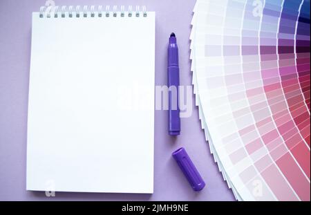 Échantillons de peinture, nuance multi-couleurs pour la conception. Arrière-plan lilas, bloc-notes, marqueur violet. Copier l'espace. Banque D'Images