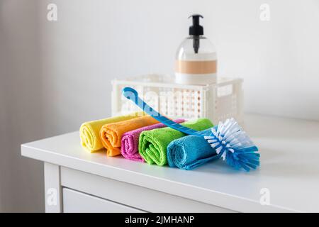 Chiffons en fibres multicolores pour l'époussetage et une brosse en plastique Banque D'Images