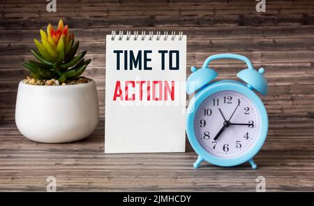 Texte TEMPS À L'ACTION texte sur bloc-notes et table en bois avec horloge, concept d'affaires Banque D'Images