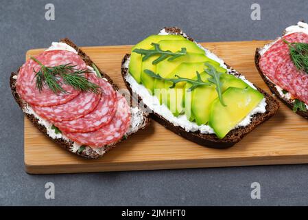 Sandwichs sains avec fromage blanc cottage, arugula, avocat, saucisse Banque D'Images