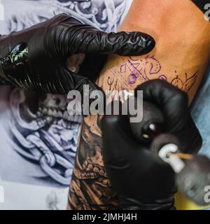 Mains gants faisant tatouage Banque D'Images