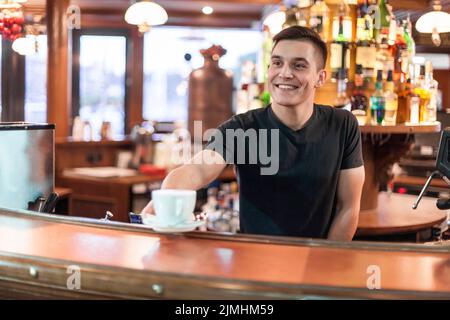 Un barista souriant donne du café Banque D'Images