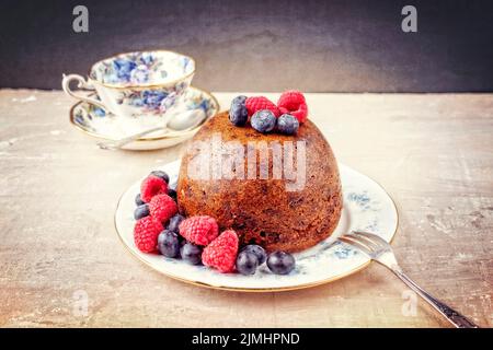 Pudding traditionnel australien aux prunes, avec fruits sur une assiette de dessert avec espace de copie Banque D'Images