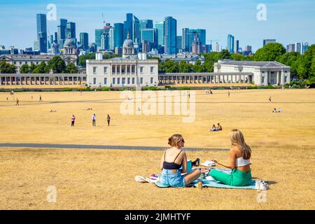 6 août 2022 - Londres, Royaume-Uni - les gens pique-niques et bains de soleil sur l'herbe séchée à Greenwich Park après une série de vagues de chaleur et des températures records, ville face à la sécheresse et mesures de rationnement de l'eau Banque D'Images