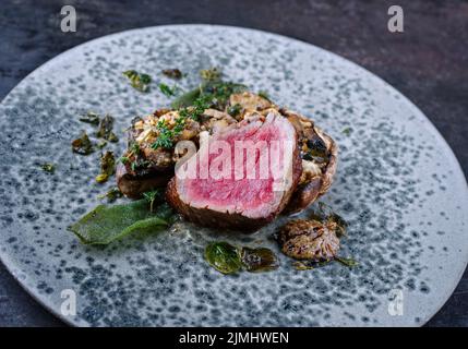 Des filets de bœuf angus frits et séchés de style moderne et naturels, accompagnés de têtes de champignons farcies et de crème de truffe, sont servis Banque D'Images
