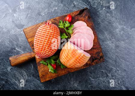 Jambon de Pâques traditionnel à la coque allemande avec tomates et persil offert comme vue de dessus sur un vieux panneau rustique en bois avec espace pour copier Banque D'Images