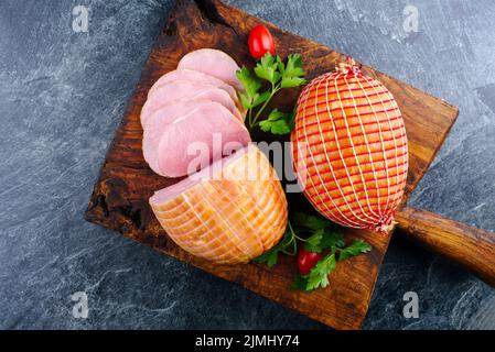 Jambon de Pâques traditionnel à la coque allemande avec tomates et persil offert comme vue de dessus sur un vieux panneau rustique en bois avec espace pour copier Banque D'Images