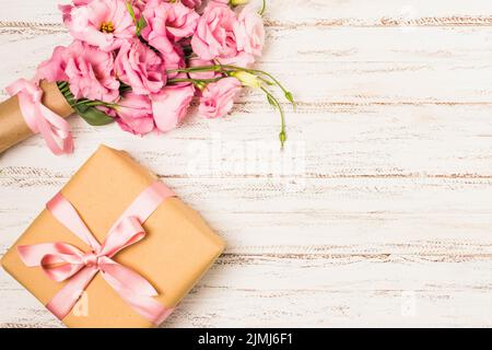 Boîte cadeau rose eustoma fleur blanche vieille table Banque D'Images