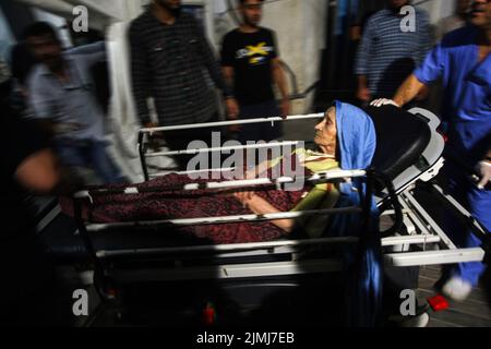 Des Palestiniens transportent une femme âgée blessée à l'hôpital d'Al-najjar après qu'un avion israélien ait frappé un bâtiment résidentiel dans le camp de réfugiés de Rafah, dans le sud de la bande de Gaza, samedi, 6 août 2022. Photo par Ismael Mohamad/UPI crédit: UPI/Alay Live News Banque D'Images