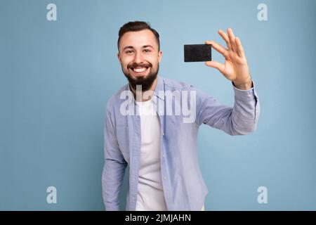 Photo de bien beau attrayant positif heureux sourire brunet unshaven jeune homme portant décontracté élégant chemise bleue et blanc t- Banque D'Images
