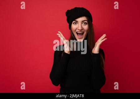 Photo de jeune positive surprise heureuse attractive brune femme avec des émotions sincères portant le chandail noir à col roulé et blac Banque D'Images
