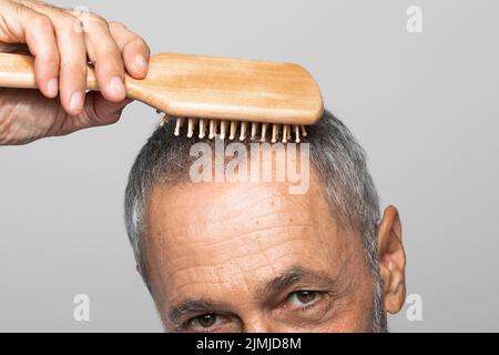Gros plan homme âgé se brossant les cheveux Banque D'Images