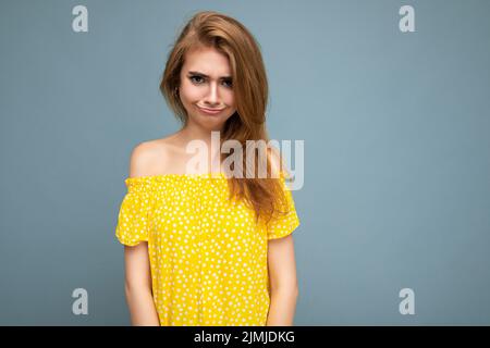 Photo de jeune mignon ravissant beau attrayant drôle malheureux blonde sombre femme avec des émotions sincères isolé sur le dos bleu Banque D'Images