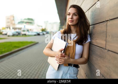 Photo de joli beau beau magnifique positif charmant jeune brune jeune femme tenant gris ordinateur portable port Banque D'Images
