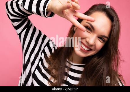 Photo en gros plan de jeune européen positif souriant winsome heureuse belle brune femme avec des émotions sincères portant décontracté St Banque D'Images