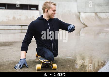 Homme handicapé motivé avec une longue planche dans le skate Park Banque D'Images