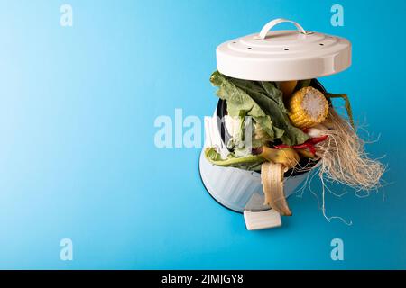 Vue en grand angle des déchets organiques dans le bac à compost par l'espace de copie sur fond bleu Banque D'Images