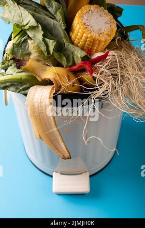 Vue en grand angle des déchets organiques dans le bac à compost sur fond bleu Banque D'Images