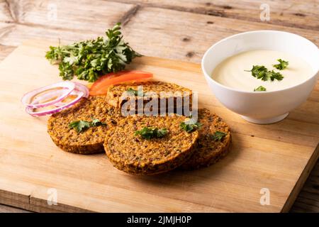 Vue en grand angle des viandes fraîches avec bol à trempette servi sur un plateau de service en bois Banque D'Images