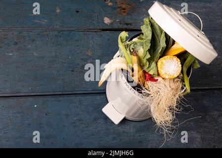 Vue en grand angle des déchets organiques dans le bac à compost sur une table en bois Banque D'Images