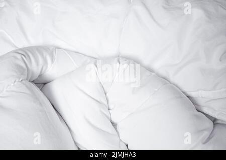 Couverture blanche. Froisser la couverture désordonnée dans la chambre après être réveillé le matin. Détails du lit. Couette et couverture, un lit non fait dans la chambre d'hôtel Banque D'Images