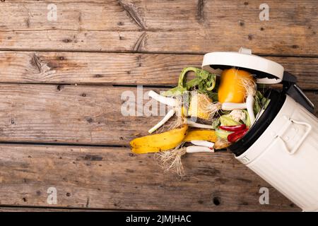 Directement au-dessus de la vue des déchets organiques renversés de la poubelle de compost sur une table en bois Banque D'Images